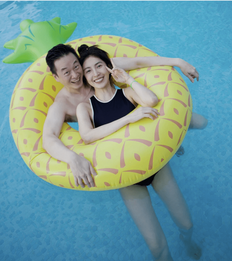 44岁的杨金华和丈夫一起游泳,共用一个游泳圈,并通过她富有的丈夫来表达她的爱。