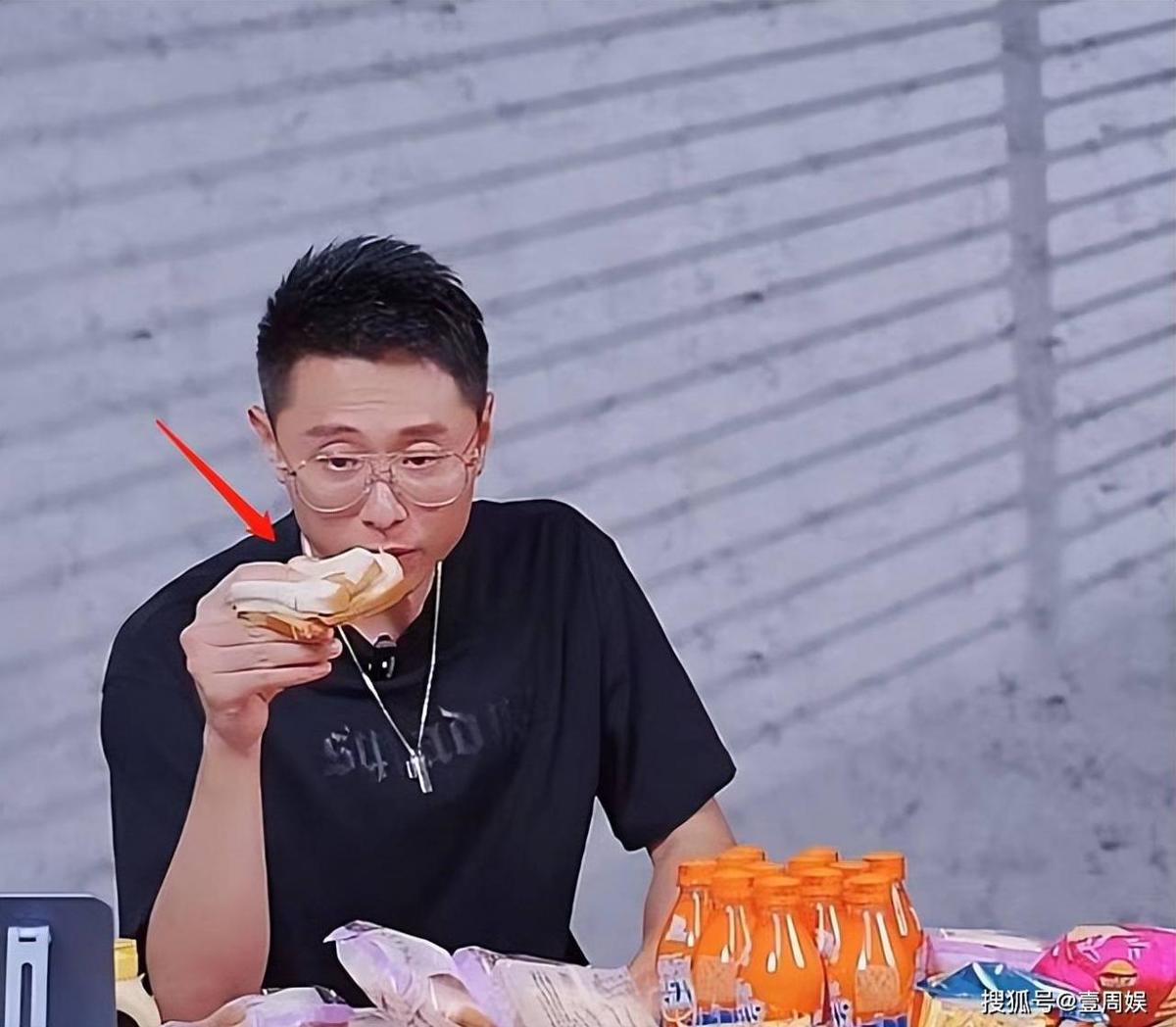 珍妮的老公在现场卖货,被面包噎着,皱着眉头,工作人员无动于衷。