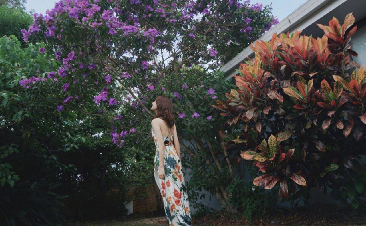 许婧在男友豪宅前拍照，男友在镜头下甜甜一笑，身穿吊带长裙，背影很美。