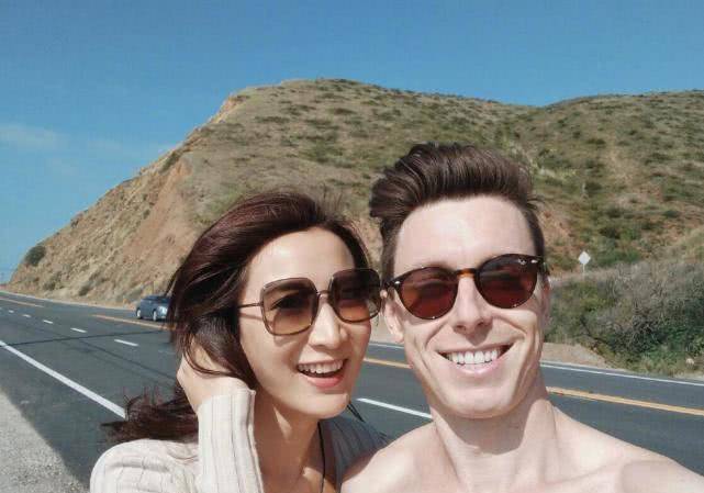 许婧在男友豪宅前拍照，男友在镜头下甜甜一笑，身穿吊带长裙，背影很美。